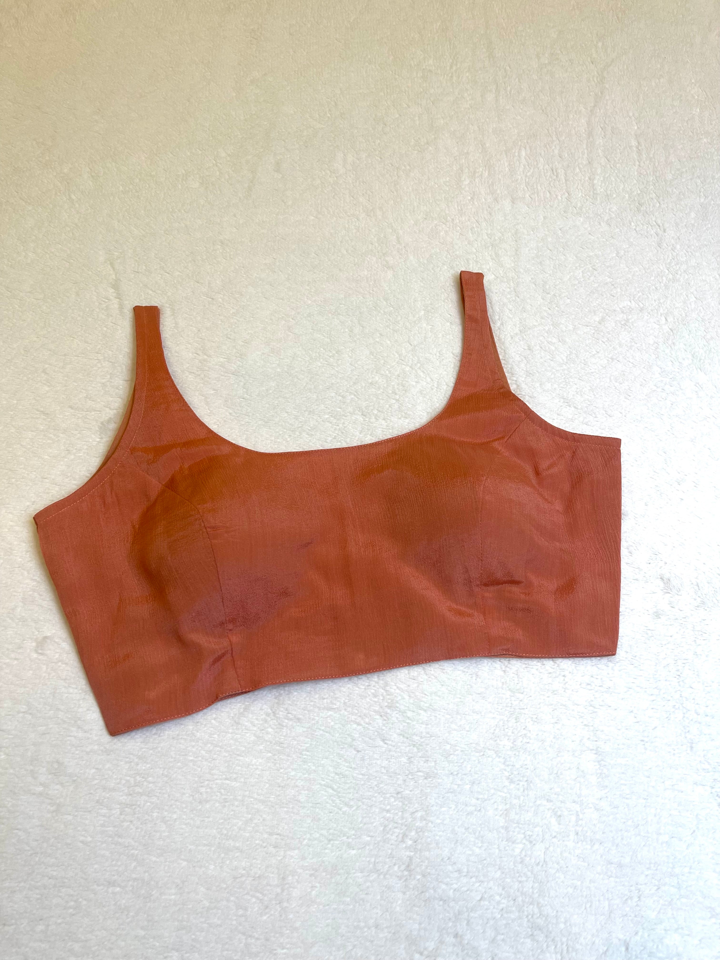 Rust chiffon sleeveless padded blouse with round neckline – fully stitched ethnic wear top on flat background