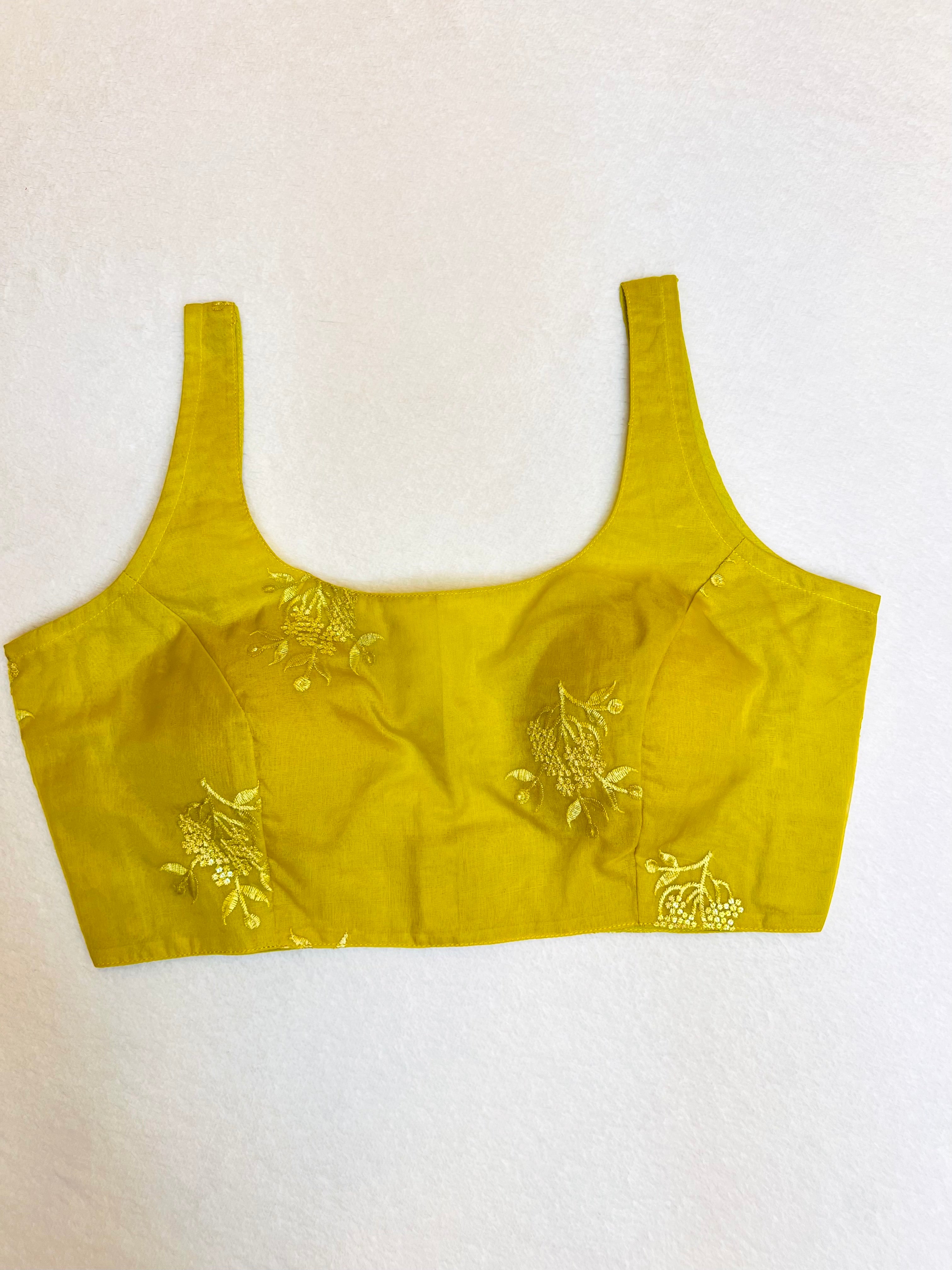 Yellow organza sleeveless padded round‑neck blouse fully stitched on flat background