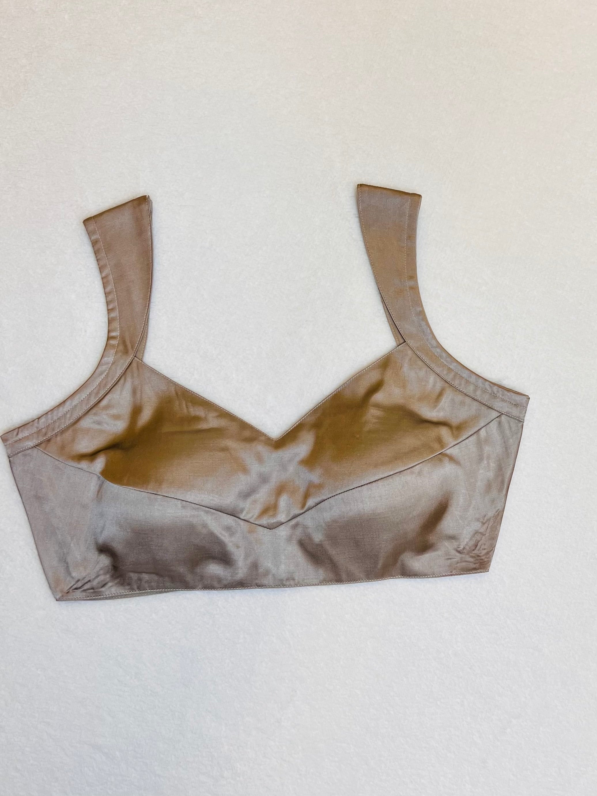 Rose gold satin sleeveless padded V-neck blouse fully stitched and laid flat for display